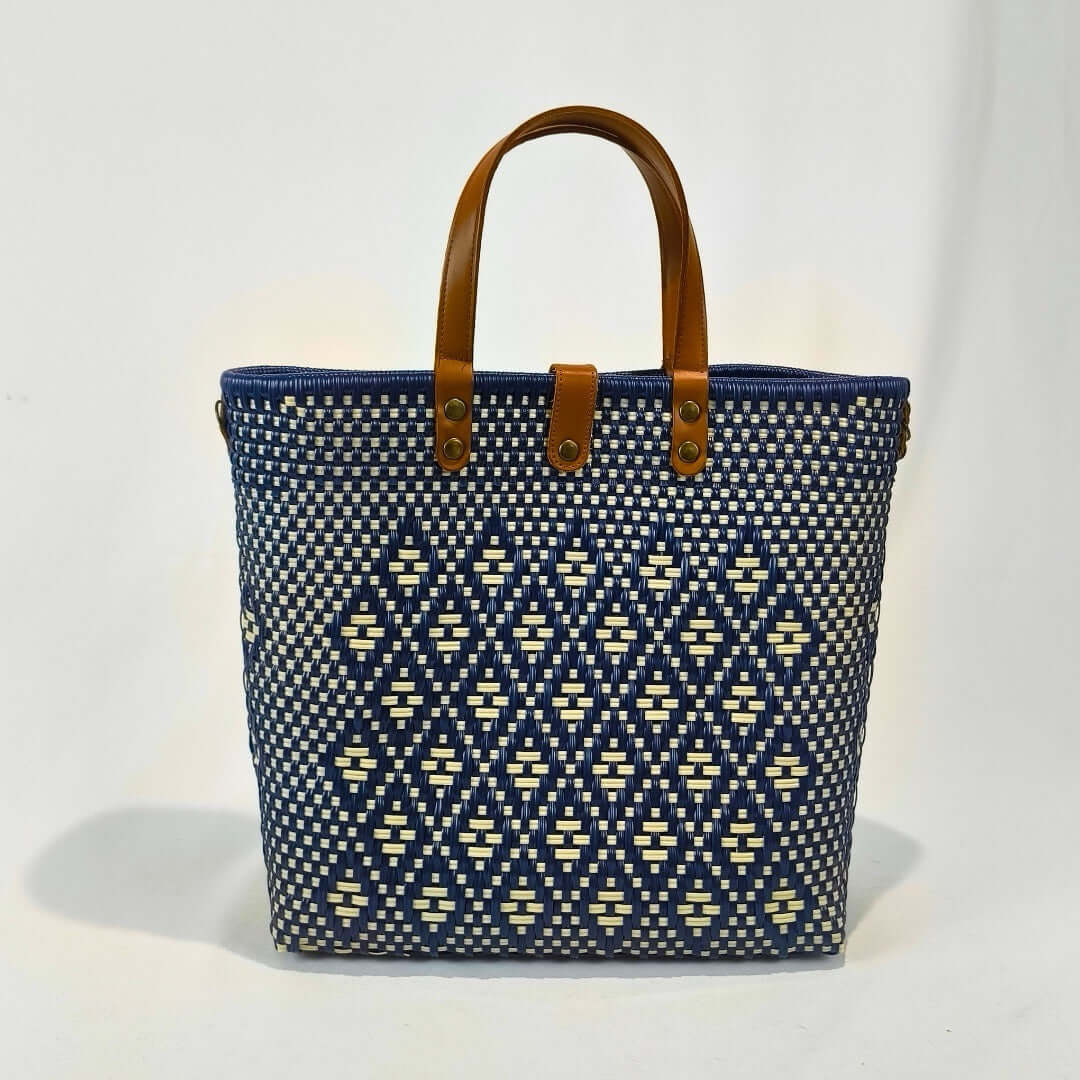 Bolsa artesanal grande color azul rey, tejida a mano con toquilla obtenida del reciclado de plástico y detalles en piel sintética color marrón. Diseño exclusivo con textura geométrica, ideal para uso diario o como accesorio de moda sostenible, hecho en México con material plástico reciclado, toquilla.