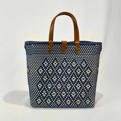 Bolsa artesanal grande color azul rey, tejida a mano con toquilla obtenida del reciclado de plástico y detalles en piel sintética color marrón. Diseño exclusivo con textura geométrica, ideal para uso diario o como accesorio de moda sostenible, hecho en México con material plástico reciclado, toquilla.
