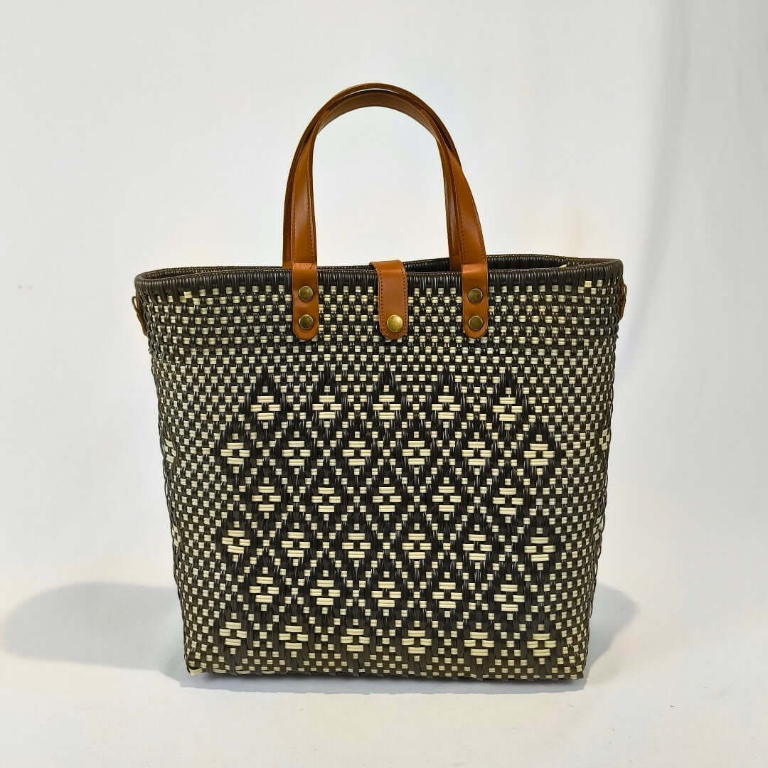 Bolsa artesanal grande color café, tejida a mano con toquilla obtenida del reciclado de plástico y detalles en piel sintética color marrón. Diseño exclusivo con textura geométrica, ideal para uso diario o como accesorio de moda sostenible, hecho en México con material plástico reciclado, toquilla.