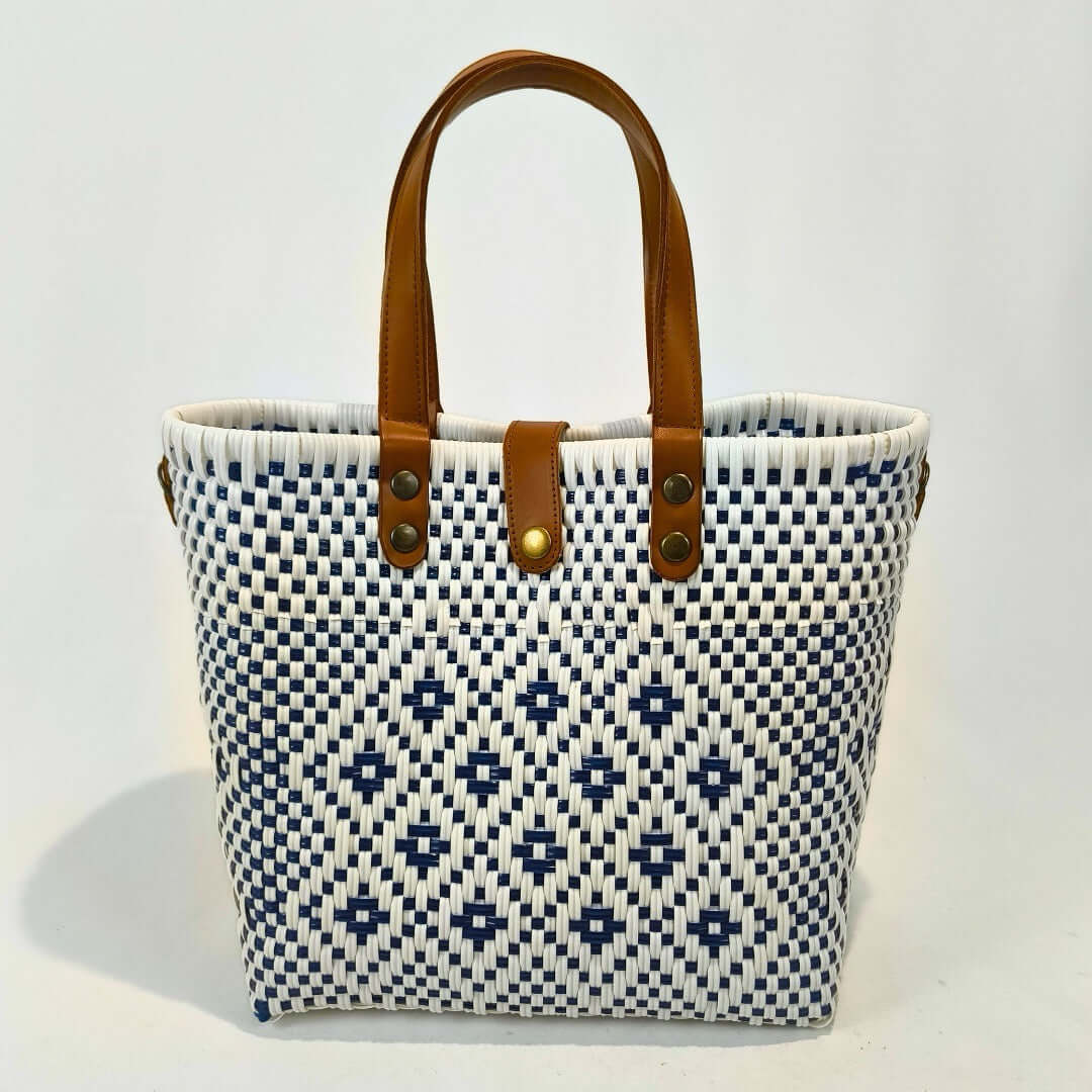 Bolsa artesanal mediana color blanco, tejida a mano con toquilla obtenida del reciclado de plástico y detalles en piel sintética color marrón. Diseño exclusivo con textura geométrica, ideal para uso diario o como accesorio de moda sostenible, hecho en México con material plástico reciclado, toquilla.