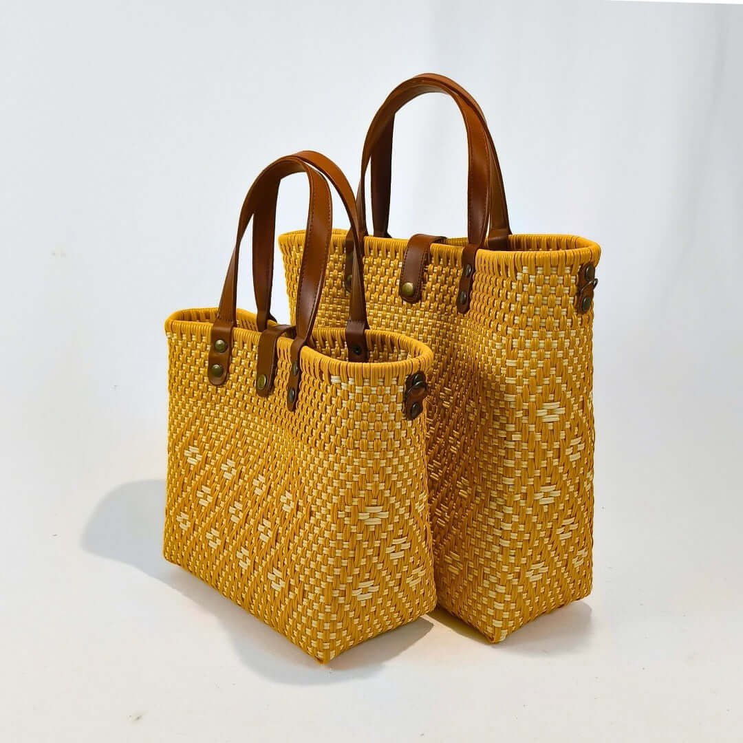 Bolsa artesanal mediana y grande color miel, tejida a mano con toquilla obtenida del reciclado de plástico y detalles en piel sintética color marrón. Diseño exclusivo con textura geométrica, ideal para uso diario o como accesorio de moda sostenible, hecho en México con material plástico reciclado, toquilla.