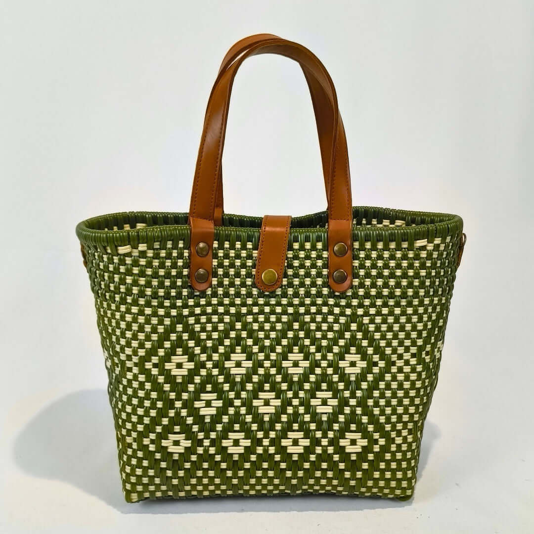 Bolsa artesanal mediana color verde, tejida a mano con toquilla obtenida del reciclado de plástico y detalles en piel sintética color marrón. Diseño exclusivo con textura geométrica, ideal para uso diario o como accesorio de moda sostenible, hecho en México con material plástico reciclado, toquilla.